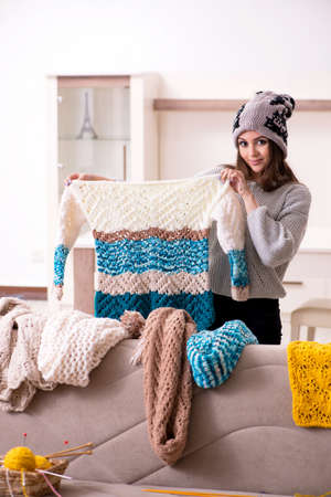 Young beautiful woman knitting at home