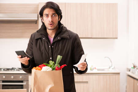 Young handsome man with vegetables in the kitchenの写真素材
