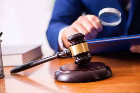 Young male judge sitting in courtroomの写真素材