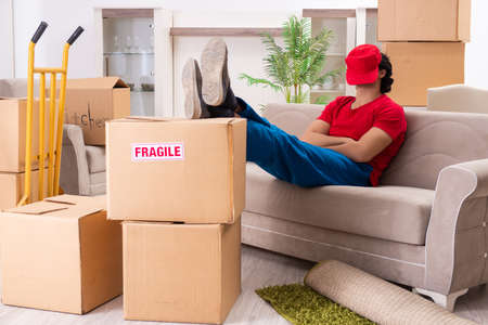 Young male contractor with boxes working indoors