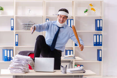 Young injured male employee working in the officeの写真素材