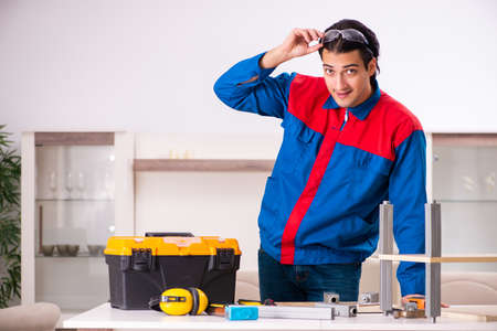 Young contractor repairing furniture at homeの写真素材