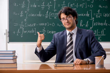 Young male math teacher in classroomの写真素材