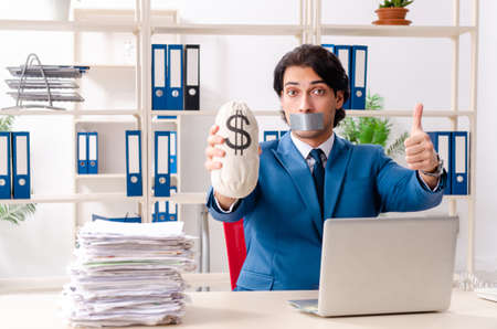 Young male employee with tape on the mouthの写真素材