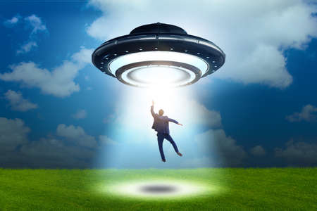 Flying saucer abducting young businessmanの写真素材