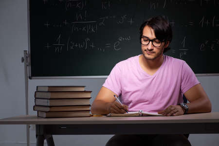 Young male student sitting in classroomの写真素材