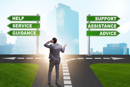 Businessman having hard choice standing at crossroadsの写真素材