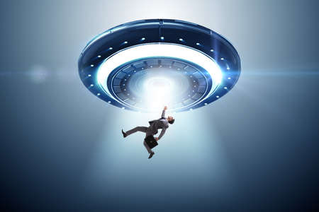 Flying saucer abducting young businessmanの写真素材