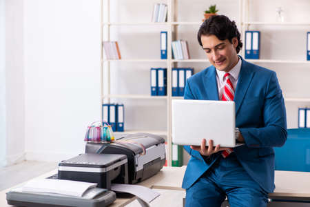 Young employee making copies at copying machine