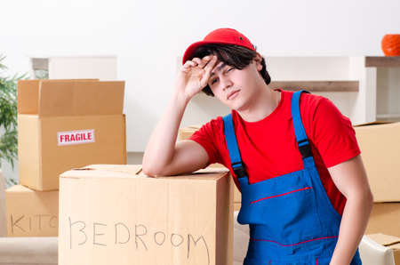 Young male contractor with boxes working indoorsの写真素材