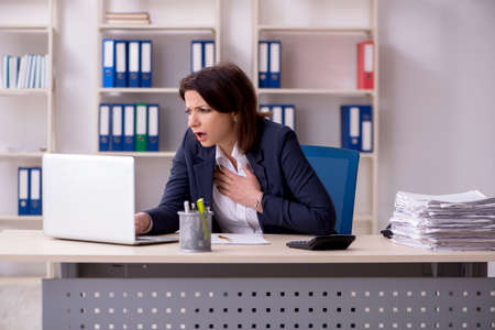 Middle-aged female employee suffering in the officeの写真素材