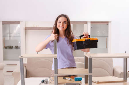 Young woman repairing chair at homeの写真素材