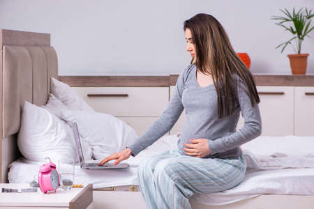 Young pregnant woman in the bedroomの写真素材