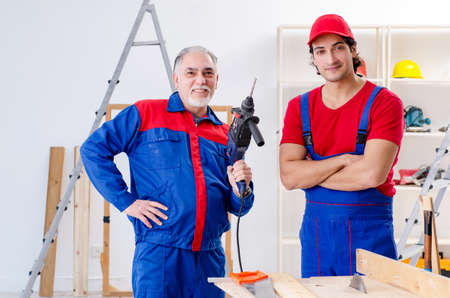 Two professional contractors laying flooring at homeの写真素材