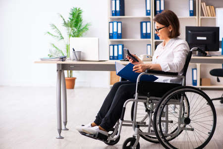 Female employee in wheel-chair at the officeの写真素材