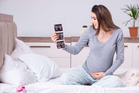 Young pregnant woman in the bedroom