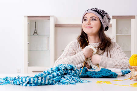 Young beautiful woman knitting at home