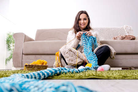 Young beautiful woman knitting at homeの写真素材