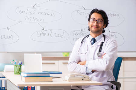Young male doctor neurologist in front of whiteboardの写真素材