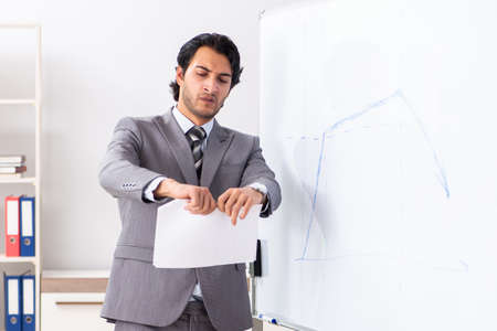 Young handsome businessman in front of whiteboardの写真素材