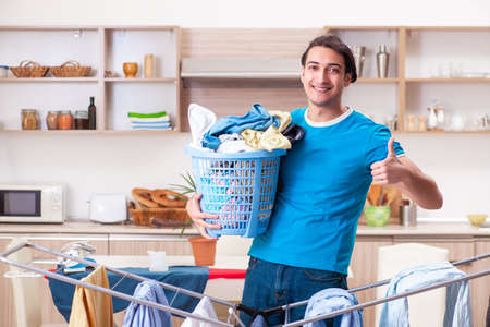 Young man husband doing clothing ironing at homeの写真素材