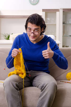 Young good looking man knitting at homeの写真素材