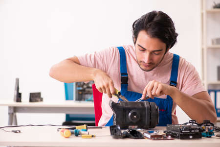 Young male contractor repairing computerの写真素材