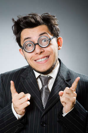 Funny nerd businessman in dark studioの写真素材