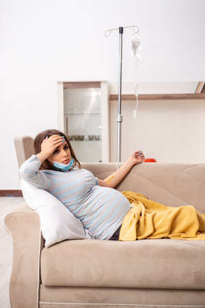 Sick pregnant woman suffering at homeの写真素材