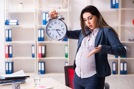 Young pregnant woman working in the officeの写真素材