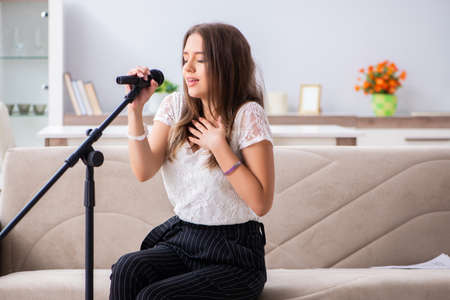 Female beautiful musician singing at homeの写真素材