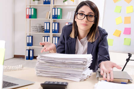 Young female employee in conflicting priorities conceptの写真素材