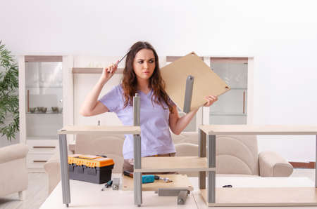 Young woman repairing chair at homeの写真素材