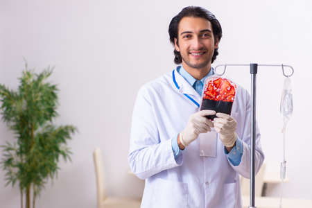 Young male doctor in blood transfusion conceptの写真素材