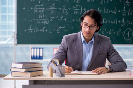 Young handsome math teacher in classroomの写真素材