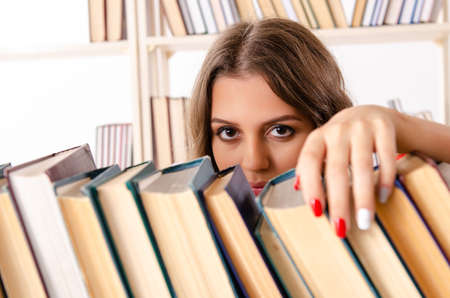 Young female student preparing for exams at libraryの写真素材