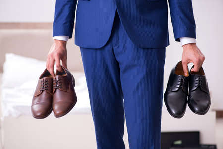 Young handsome businessman choosing shoes at homeの写真素材