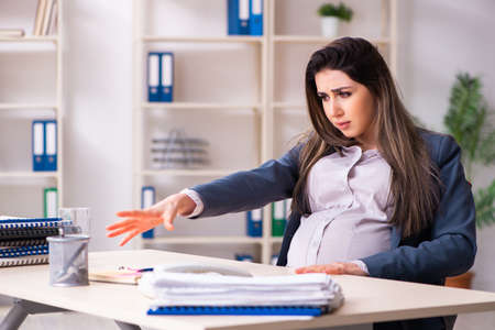 Young pregnant woman working in the officeの写真素材