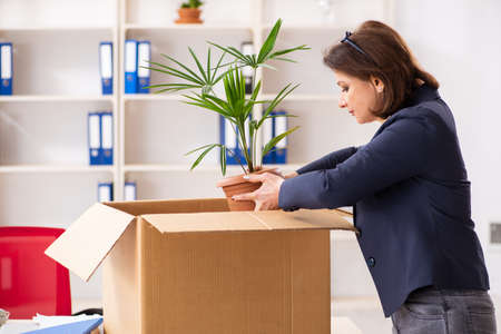 Middle-aged female employee being fired from her workの写真素材