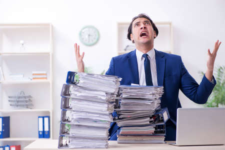 Young male employee unhappy with excessive work