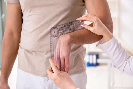 Female doctor checking patients joint flexibility with goniometerの写真素材
