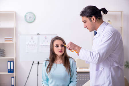 Young woman visiting male doctor oculistの写真素材