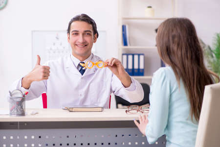 Young woman visiting male doctor oculistの写真素材