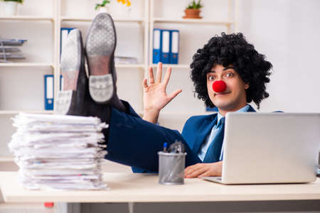 Young clown businessman working in the officeの写真素材