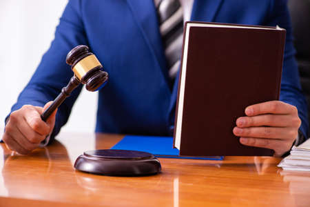 Young male judge sitting in courtroom