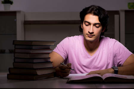 Male handsome student preparing for exams late at home
