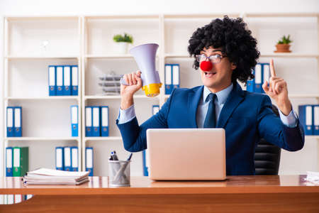 Young clown businessman working in the officeの写真素材