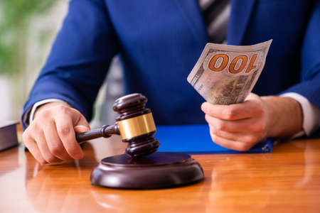 Young male judge sitting in courtroomの写真素材