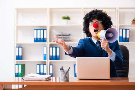 Young clown businessman working in the officeの写真素材