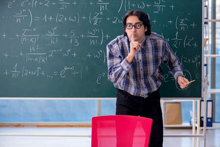 Young funny math teacher in front of chalkboardの写真素材